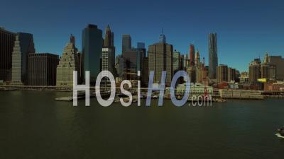 Nyc New York Usa Low Flying Backwards Over East River With Manhattan Financial District Cityscape View And Large Barge - Video Drone Footage