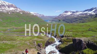 Aerial View Over A High Mountain Fjord In Iceland, The Village Of Seydisfjordur Distant - Video Drone Footage