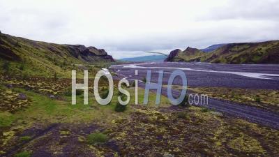 Vue Aérienne Sur Un Bus Conduisant à Côté D'une Rivière Dans Les Hautes Terres D'islande - Vidéo Drone
