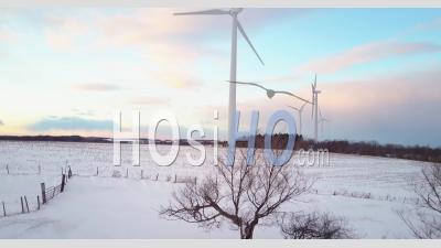 Aerial View Over Wind Generation Turbines In A Snowy Landscape - Video Drone Footage
