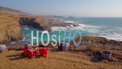 Une Femme Se Détend Dans Une Chaise De Plage Le Long De La Côte De Big Sur, Californie - Vidéo Drone