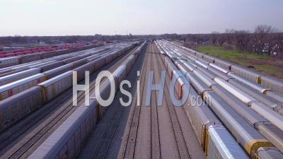 Aerial View Over A Railroad Yard Suggests Shipping, Commerce, Trade Or Logistics - Video Drone Footage