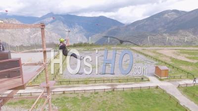 Aerial View Of A Man Ziplining On A Zipline From A Tall Tower In Andorra, Europe - Video Drone Footage