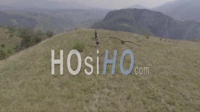 Vue Aérienne De Personnes Marchant Sur Une Colline Près Du Village De Lukomir En Bosnie, Ancienne Yougoslavie - Vidéo Drone