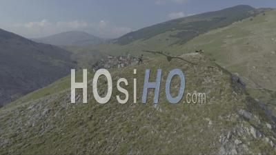 Aerial View Of People Walking On Hilltop Near Ancient Quaint Lukomir Village In Bosnia, Former Yugoslavia - Video Drone Footage
