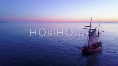 Aerial View Of A Tall Sailing Ships On The Open Ocean At Sunset - Video Drone Footage