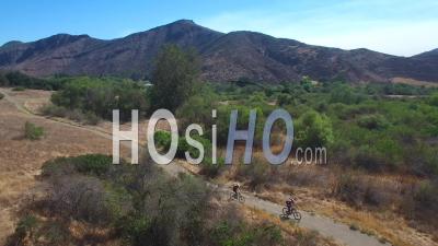 Aerial View Of Two Mountain Bikers Riding In The California Mountains - Video Drone Footage