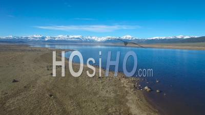 Aerial View Over A Mountain Lake Reveals The Sierra Nevada Mountains In Winter - Video Drone Footage