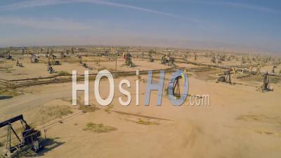 Aerial View Over Vast Oil Fields And Derricks Near Bakersfield, California - Video Drone Footage