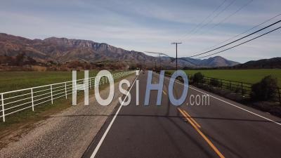 Aerial View Of A Man Riding A Motorcycle Through A Valley In Central California Near The Ojai Valley - Video Drone Footage