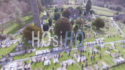 Aerial View Over The Glendalough Cemetery In Ireland With Graves And Visitors - Video Drone Footage