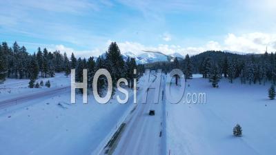 2020 - Aerial Video Of Cars Driving Slowly On Icy Snow Covered Mountain Road In The Eastern Sierra Nevada Mountains Near Mammoth California - Video Drone Footage