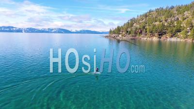 2020 - A Man Rides A Hydrofoil Efoil Electronic Surfboard Across Lake Tahoe, California In An Extreme Hydrofoiling Foil Sport Demonstration - Video Drone Footage
