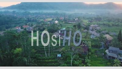 Village Agricole Indonésien Dans Un Matin Enfumé Avec Un Ciel Rose - Vidéo Aérienne Par Drone