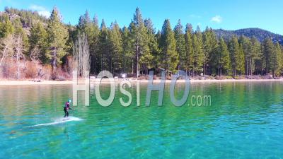 2020 - A Man Rides A Hydrofoil Efoil Electronic Surfboard Across Lake Tahoe, California In An Extreme Hydrofoiling Foil Sport Demonstration. - Video Drone Footage