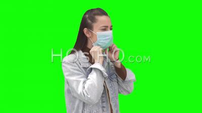 Young Woman Putting On Face Mask