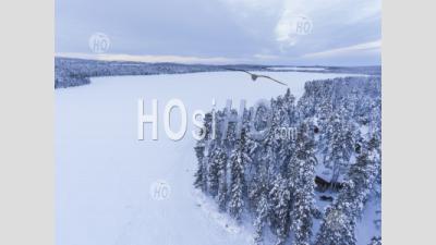 Snow Covered Lake And Forest Winter Landscape Showing Amazing Lapland Scenery In Scandinavia In Finland Drone