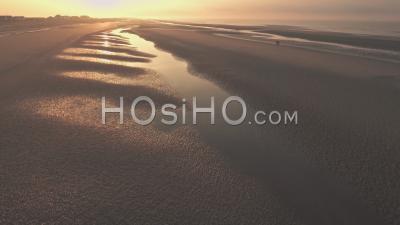 Couple Of People On Camber Sands Beach At Sunset, East Sussex, England. Aerial Drone View