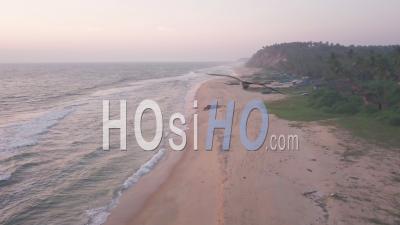 Vue Aérienne Par Drone Vue Sur La Côte De Varkala Avec Des Vagues Qui Se Brisent Sur La Plage De Sable, Au Kerala, En Inde, Au Crépuscule