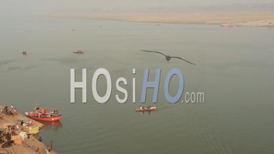 Orange Boats Sailing On The Trans-Boundary River Of Ganges Located In Varanasi, Uttar Pradesh, India. -Wide Shot