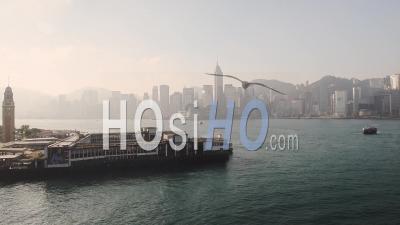 Star Ferry Boat Quittant La Jetée De Tsim Sha Tsui Avec La Célèbre Tour De L'horloge Dans Le Port De Victoria, Hong Kong Pendant Le Lever Du Soleil. - Plan Large