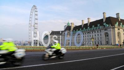 Convoi De La Police De Motos à Londres à Coronavirus Covid-19 Lockdown Avec Calme Et Vides Routes Et Rues Désertes à Westminster Bridge Et London Eye En Angleterre, Royaume-Uni