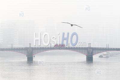 Central London City Skyline With Iconic Red London Bus Driving Over Lambeth Bridge With Misty Foggy Skyscraper Buildings Shot In Coronavirus Covid-19 Lockdown In England, Uk