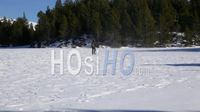 Man Walking With Rackets On A Frozen Lake