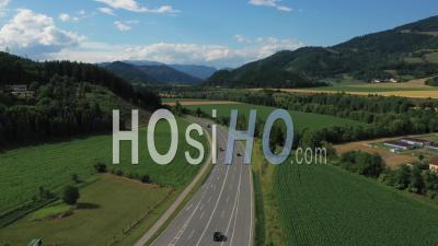 Road Along The Austrian Mountains And Green Meadows - Video Drone Footage