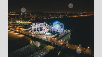 Santa Monica Pier At Night In Super Colourful Lights From Aerial Drone Perspective In Los Angeles, California Hq