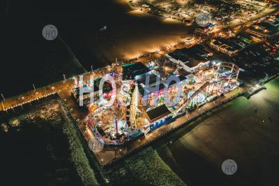 Santa Monica Pier At Night In Super Colourful Lights From Aerial Drone Perspective In Los Angeles, California Hq