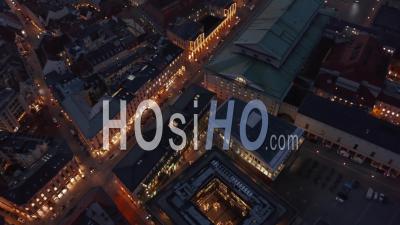 Scenic Aerial View Passing Through Munich, Germany Neighborhood Street At Night With Beautiful City Lights Glowing And Cars Passing By, Aerial Tilt Down High Angle - Video Drone Footage
