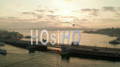 Galata Bridge Over Bosphorus In Golden Sunrise Light With Boats On Water, Aerial Establishing Shot Slide Left - Video Drone Footage