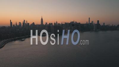 Over East River Overlooking Manhattan New York City Skyline In Beautiful Dawn Sunset Orange Light 4k - Video Drone Footage