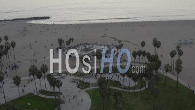 Voler Loin Du Skatepark De Venice Beach Avec Des Visiteurs Et Des Palmiers, Coucher De Soleil à Los Angeles, Californie 4k - Vidéo Par Drone