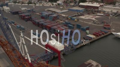 Close Up Aerial View Of The Truck Driving In The Container Terminal With Blue And Red Containers 4k - Video Drone Footage