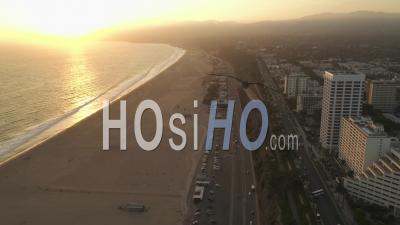 Vue De Haut De L'autoroute De La Côte Du Pacifique à Côté De La Jetée De Santa Monica, Los Angeles Avec Trafic Léger Et Vue Sur L'océan Par Au Coucher Du Soleil, été 4k - Vidéo Aérienne Par Drone