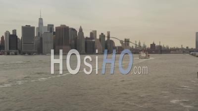 Low Flying Aerial View Following A Large White Boat Arriving Into The New York City Port With City Skyscrapers On The Water Banks 4k - Video Drone Footage