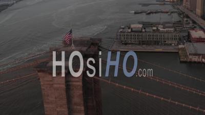 Close Up Circle Flight Over Brooklyn Bridge With American Flag And East River View Manhattan New York City Skyline In Beautiful 4k - Video Drone Footage