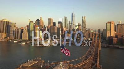 Flight Over Brooklyn Bridge With American Flag Waving And East River View Over Manhattan New York City Skyline In Beautiful 4k - Video Drone Footage
