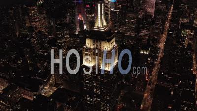 Breathtaking Wide View The Iconic Empire State Building Disappearing Behind Residential Condominiums And Office Buildings In Midtown Manhattan, New York City At Night 4k - Video Drone Footage