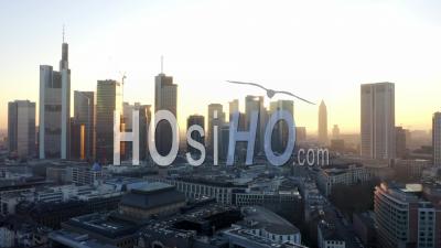 Aerial View Of Frankfurt Am Main, Germany Skyline With Golden Yellow Sunflair Between Skyscrapers In Beautiful Sunset Sunlight In Winter Haze 4k - Video Drone Footage