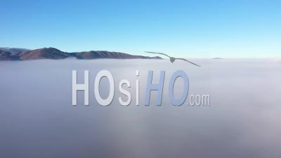Aerial View Of Rural Landscape In Mystic Morning Haze Above Clouds - Video Drone Footage