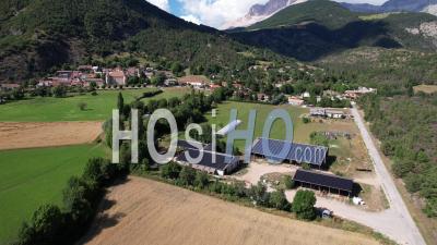 Photovoltaic Solar Panels On The Roofs Of Agricultural Buildings, Hautes-Alpes, France, Viewed From Drone