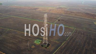 Electric Pylon In The Dry Cultivated Agricultural - Video Drone Footage