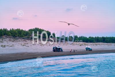  Off Road Campervans And Travellers Standing On Sandy Beach Against Red Evening Sky - Aerial Photography