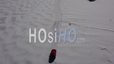 A Car Drives Across A Frozen Lake - Video Drone Footage