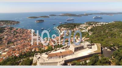 An Aerial View Of Hvar, Croatia, Highlights The Tvrdava Fortica And Boats Coming In To The Harbor - Video Drone Footage