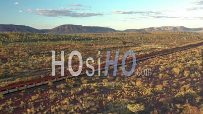 2021 - Vue Aérienne D'un Train De Charbon Passant Devant Des Arbustes Et Des Montagnes à Tom Price, Australie - Vidéo Par Drone