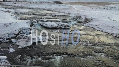 Vue Aérienne Se Déplaçant En Amont Le Long D'une Rivière En Islande, Passant Le Long D'un Paysage Montagneux Hivernal - Vidéo Par Drone